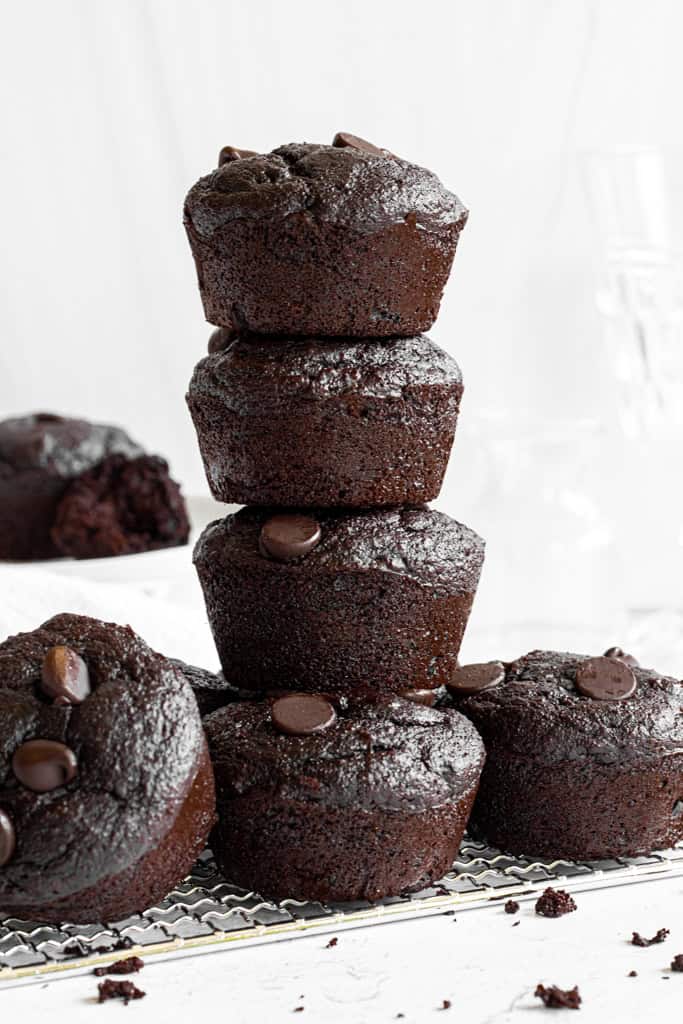 chocolate banana muffins stacked on top of each other and topped with chocolate chips