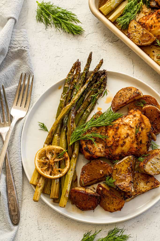 chicken with asparagus and potatoes topped with lemon and dill 
