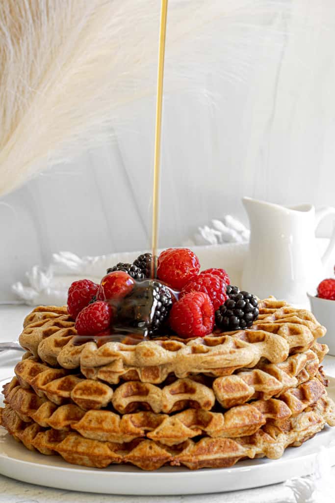 oat waffles with maple syrup drizzle and raspberries, blackberries