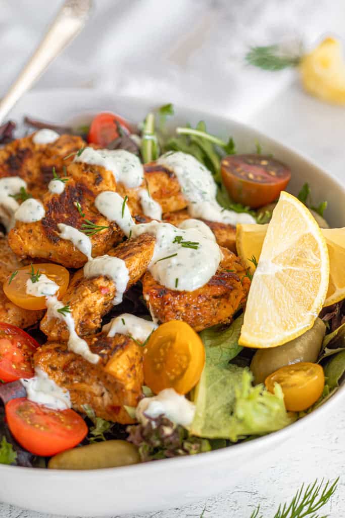 greek gyro chicken salad with greek yogurt sauce and lemon, red cherry tomatoes, spring mix greens